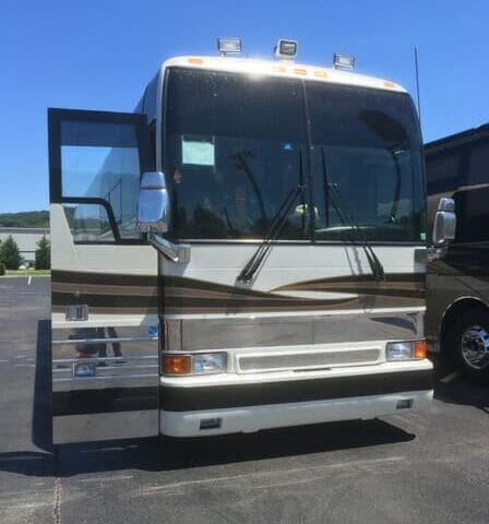 A white tour bus with gold highlights